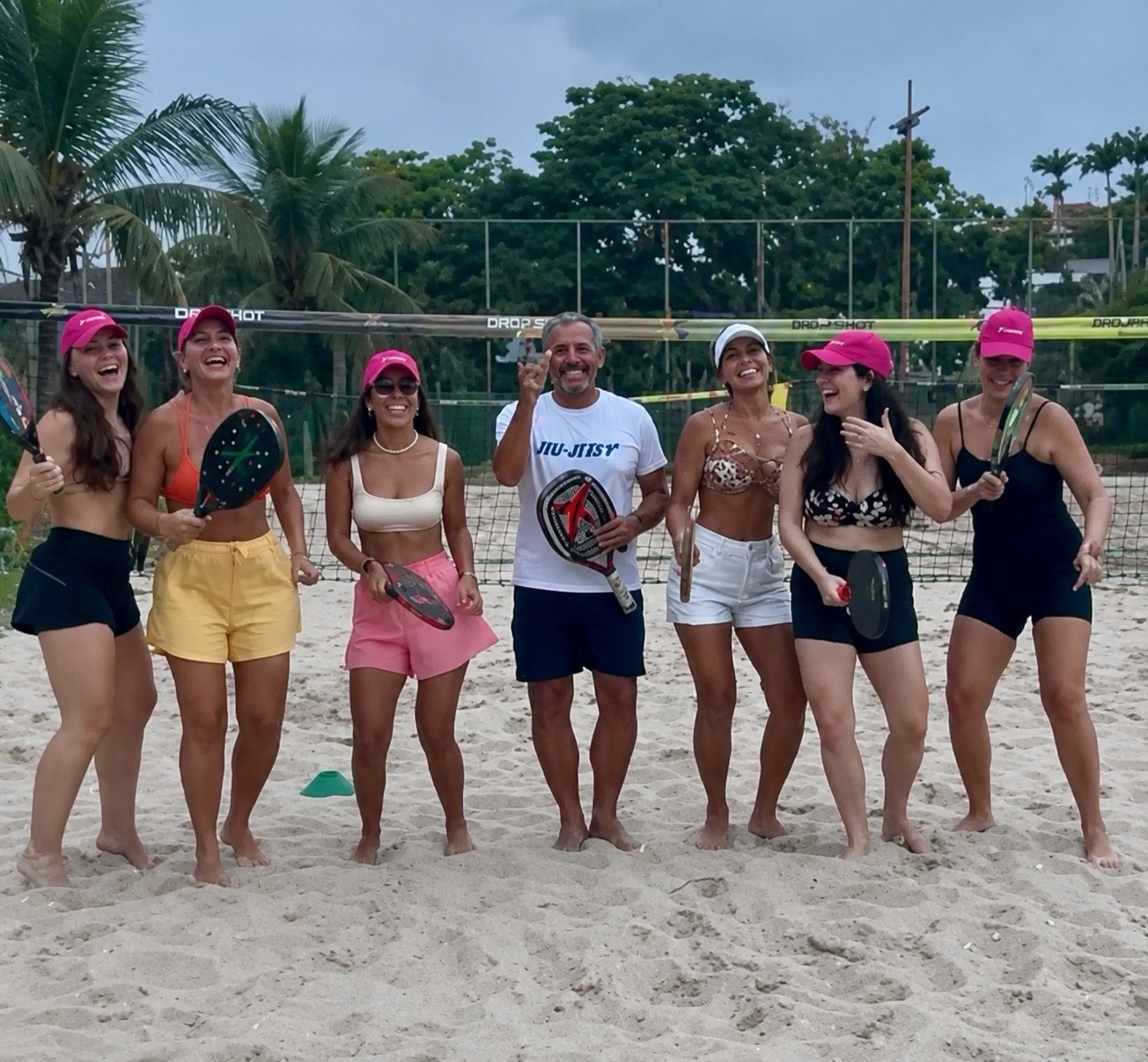 Grupo de alunas e professor da Arena BS após treino de beach tennis
